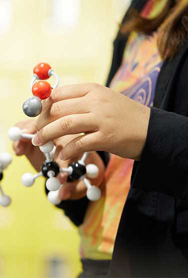 a student holding the model of a molecule