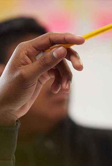a hand holding a pencil pointing