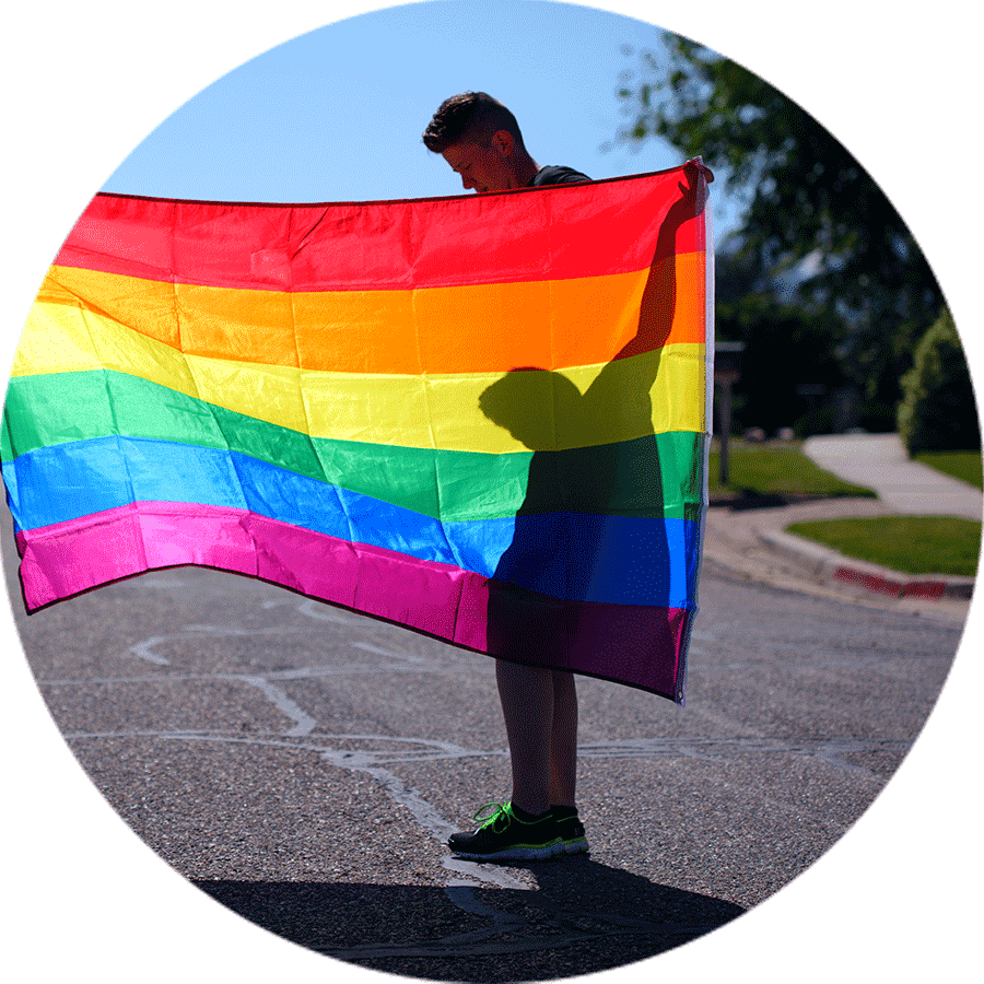 student holding rainbow flag