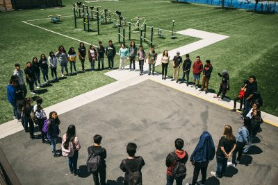 Students gathered and forming a circle in a high school park