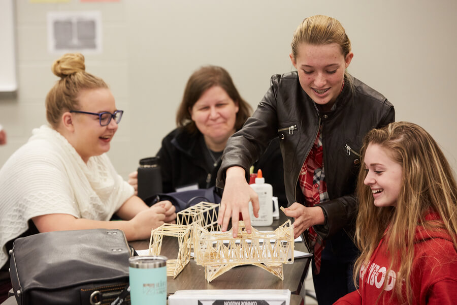 Students at PSI high building a toothpick bridge to learn engineering skills and practice project-based learning