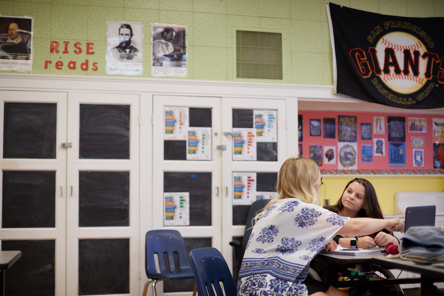 Two teachers plan a reading instruction lesson plan for students in a classroom.