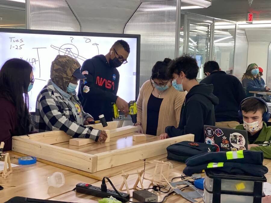 students around a table making a wood project